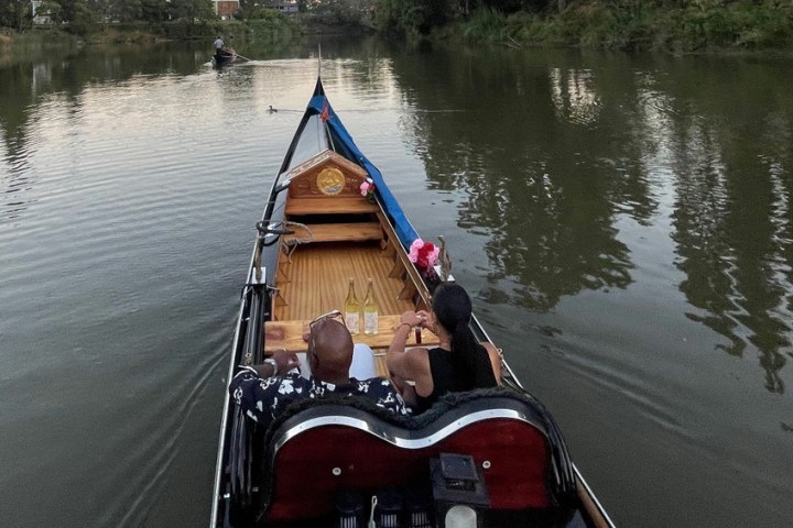 a boat floating along a river next to a body of water