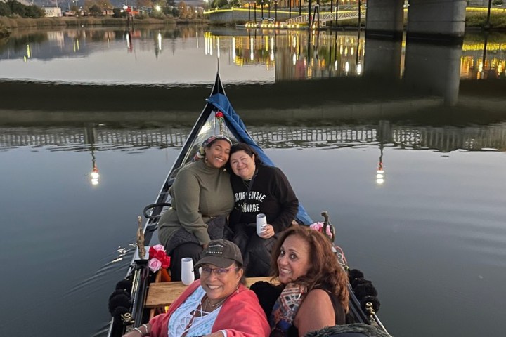a boy sitting in a boat on a body of water