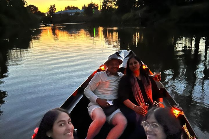 a group of people sitting next to a body of water