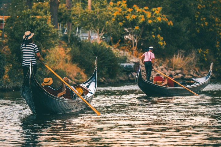 a man riding on the back of a boat in the water
